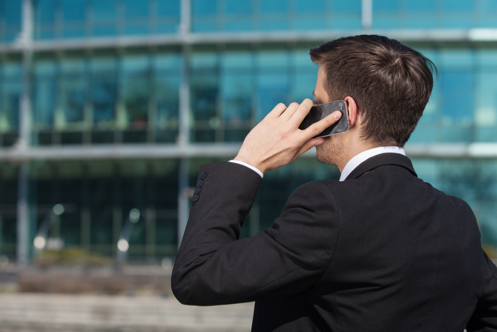 homem de terno falando no celular