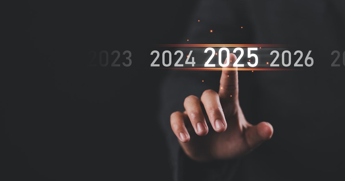 Um fundo escuro com números de anos (2023, 2024, 2025, 2026) alinhados horizontalmente. A imagem foca em uma mão que está apontando para o ano "2025", destacado com um brilho alaranjado ao redor com as tendências para este ano (zendesk)