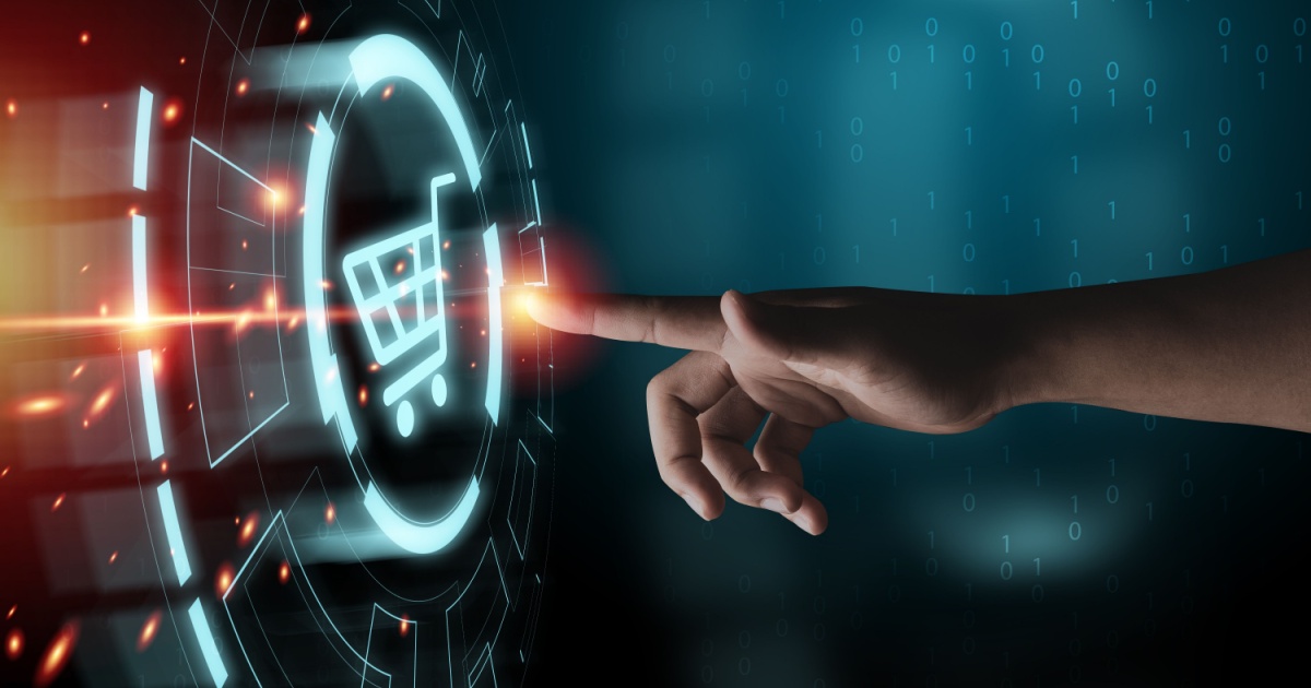 Mão humana tocando um ícone digital de carrinho de compras em uma interface futurista, com elementos gráficos e luzes brilhantes. A imagem representa compras online, e-commerce e tecnologia no varejo (compras, procurement, shop, e-commerce, varejo, gartner, nuvemshop, visa)