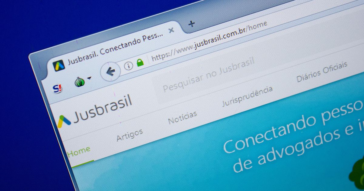 Captura de tela de uma janela de navegador exibindo o site Jusbrasil. A URL visível na barra de endereços é "https://www.jusbrasil.com.br/home". A aba do navegador mostra o logotipo do Jusbrasil e o texto "Jusbrasil. Conectando Pess...". Abaixo da barra de endereços, há opções de navegação como "Home", "Artigos", "Notícias", "Jurisprudência", entre outras. A área principal do conteúdo tem fundo azul com texto branco parcialmente visível que diz: "Conectando pessoas de advogados e i...".